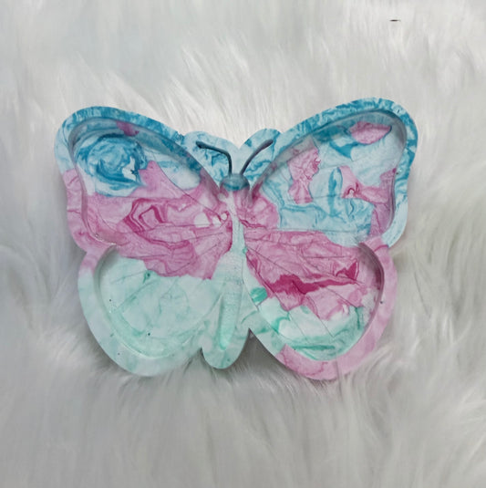 A butterfly-shaped decorative tray or dish with a marbled pattern in pink, blue, and mint green