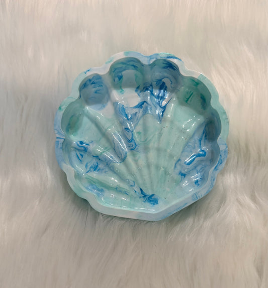 A scallop-shaped resin dish with a marbled blue and white seashell pattern